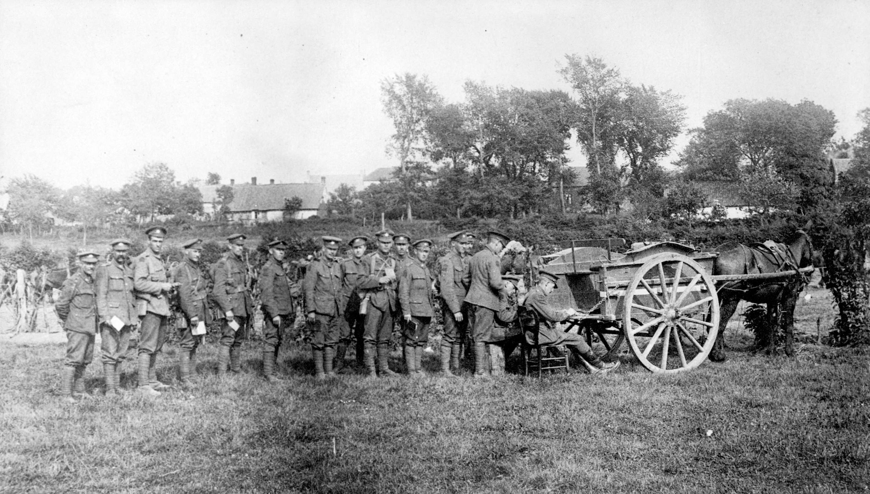 Men of the 7th Battalion C.E.F. lined up to receive pay on the battlefield from paymaster Major P.M. Ferris.jpg