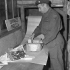 Private Leon Biron of No.1 Army Base Post Office, Canadian Postal Corps (C.P.C.), rewrapping damaged parcels, Dieppe, France, 11 October 1944.