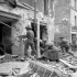Infantrymen of The Regina Rifle Regiment and a despatch rider firing into a damaged building, Caen, France, 10 July 1944.