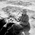 Captain E.N. Frost of The North Nova Scotia Highlanders, whose hand grenades are ready for use as he writes a letter home from his slit trench in Normandy, France, 22 June 1944.
