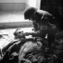 Private B.D. Flynn of the Regimental Aid Party, The Seaforth Highlanders of Canada, giving a drink of water to a badly-wounded German prisoner inside a church, Catona, Italy, 21 December 1943.