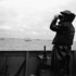 Lookout on the flagdeck of H.M.C.S. PRINCE DAVID watching assault craft  heading ashore to the Normandy beachhead, France, 6 June 1944.