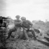 Privates R.T. Crawford and W.M. Stairs sitting on an unused German 500-pound bomb, Carpiquet, France, 12 July 1944.