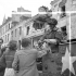Corporal J.R. Pelletier of the 17th Duke of York's Royal Canadian Hussars, who is riding in a Universal Carrier, passing out cigarettes to French civilians, Caen, France, 10 July 1944.