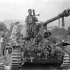 Lance-Corporal J.A. Thrasher of The Westminster Regiment (Motor), who holds the PIAT anti-tank weapon with which he disabled the German self-propelled 88mm. gun on which he is sitting, near Pontecorvo, Italy, 26 May 1944.