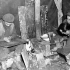 Gunners George Blagdon and Frank Klein and Sergeant Leonard Tremblay, all of the Royal Canadian Artillery (R.C.A.), making a stove from a 4.5-inch shell charge case, Ravenna, Italy, 10 February 1945.