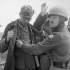 An unidentified Corporal despatch rider searching a  German soldier who was captured in Normandy, Southampton, England, ca. 8-10 June 1944.