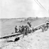 Canadian soldiers draining gasoline from a damaged Messserschmidt 109 aircraft that crash-landed beside a German radar station near Beny-sur-Mer, France, 16 June 1944.