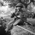 Lieutenant L.L. Smith of the 9th Canadian Infantry Brigade resting by a slit trench during heavy shelling in the Normandy bridgehead, France, ca. 8-9 June 1944.