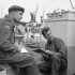 Lieutenant John MacIsaac (left), 14th Field Regiment, Royal Canadian Artillery (R.C.A.), discussing D-Day fire plan tactics with Bombardier Charles Zerdwell aboard a Landing Ship Tank, Southampton, England, 4 June 1944.